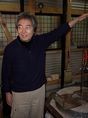 Hosokawa Morihiro in front of Raku Kiln showing flame height Hosokawa Morihiro in front of Raku Kiln showing flame height