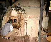 Mitsuru Isezaki peering into his kiln.